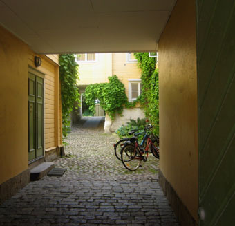 Inblickar från gatan in mot gårdarna kan innebära stora miljökvaliteter. Här en portik vid Köpmangatan som också medger genom-passage. Foto: Mats Ohlin, aug 2009.